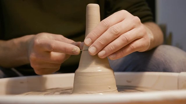 Handicraftsman create product on the circle potterswheel close up isolated. Artisan dexterity and skilfully sculpt traditional culture brown vase or cup. The creativity leisure, creating job of artist