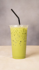 Ice tea or ice coffee with milk on wood background.