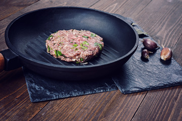 Minced meat cutlet with herbs and garlic on a cast iron grill pan