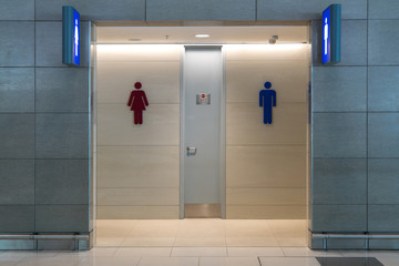Front view of public restroom or toilet with man and women signs on marble wall. Way to clean...