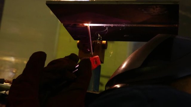 Professional welder works with electric welding tool