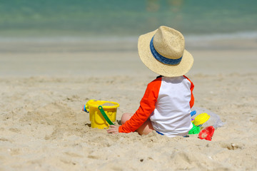 Two year old toddler playing on beach