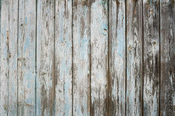 Weathered painted blue peeling wooden fence.