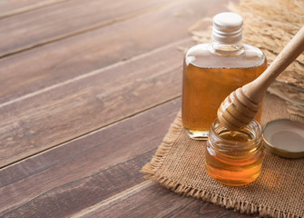 Obraz na płótnie Canvas Honey with wooden honey dipper on wooden table