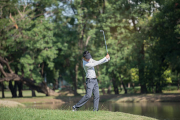 Golfers asia man show hit sweeping at green lawn.
