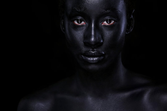 Cheerful young african woman with art fashion makeup. An amazing woman with black bodyart
