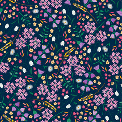 Seamless tossed floral pattern with snowdrops, daisies, angelica, bluebells and thistles on a dark blue background