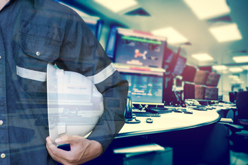 Double exposure of Engineer or Technician man holding safety hat with computer control room for stock and control process industrial business concept