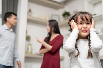 Domestic violence and Family conflict concept. Sadness little girl against blured of mother...