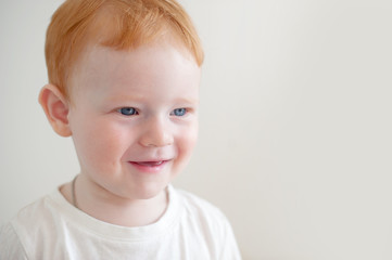 Smiling redhead boy on the white background