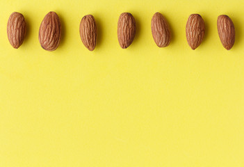  row of almonds on a bright yellow background
