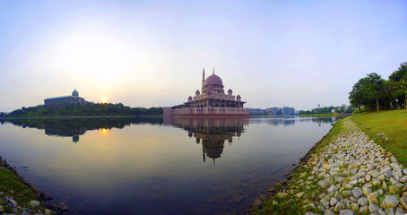 Obraz premium Superlarge megapixel Panoramic view of majestic mosque during sunrise with mirror reflection in the lake.