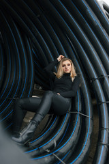 a girl in a canopy of pipes looking out into the distance