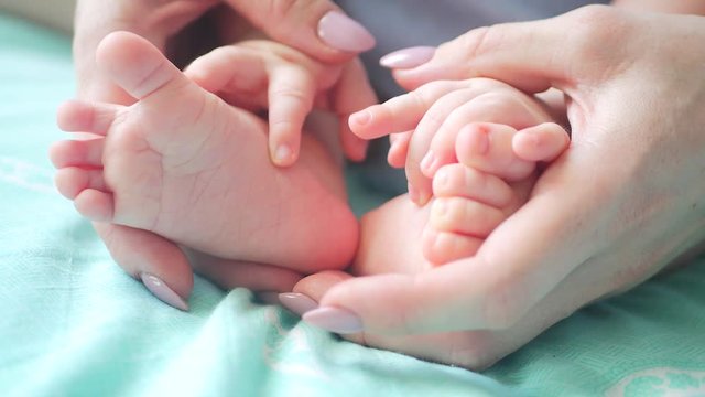 mother's hands holding small baby's feet