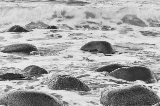 Fototapeta Scenic seascape natural background, Atlantic shore with waves and stones, black and white image