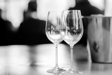 Natural light or daylight shot of modern restaurant table set for a lunch. Shallow focus on wine glass. Black and white background