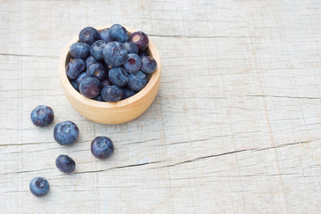 Selective focus blueberries in wooden bowl. Concept for healthy eating and nutrition