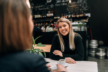 Friends having a cup of coffee at the modern cafe.