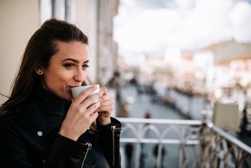 Close-up image of a cute girl relaxing on the terrace with a cup of coffee.