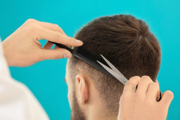 Obraz premium Professional hairdresser working with client on color background