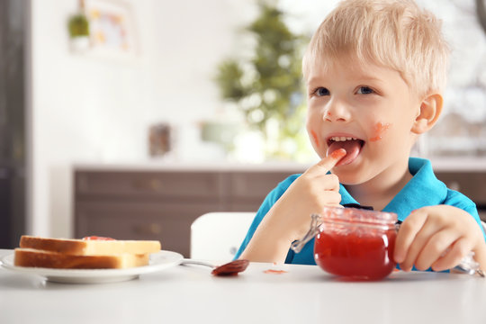 Cute little boy with jar of jam at home