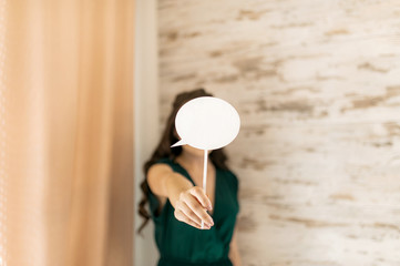 Girl holding big bright candy or sign in front of her