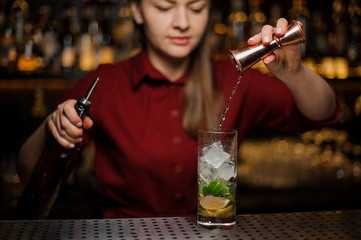 barmaid the blonde finishes preparation of an alcoholic cocktail mojito
