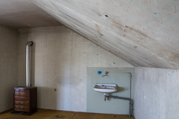 Desolates Zimmer mit Dachschräge in renovierungsbedürftigem Haus