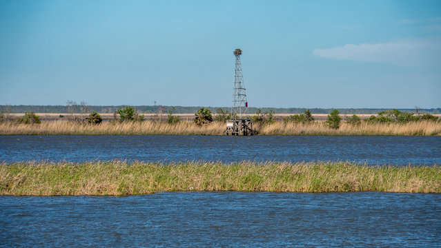 A waterway on Florida's panhandle in a saltwater marsh. A tower in the distance marks the channel and holds an osprey nest.