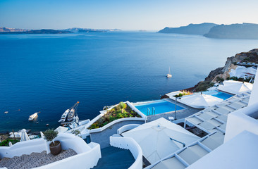 White architecture at Santorini island. Swimming pool in romantic luxury hotel at Oia town. - obrazy, fototapety, plakaty
