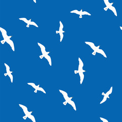 Beautiful flying seagulls in the blue sky seamless pattern