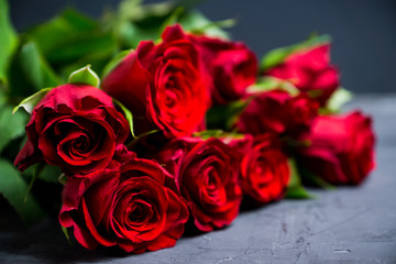 Bouquet with red roses on the rustic background. Shallow depth of field.