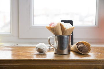 Variety of ice cream scoops in cones with chocolate, vanilla and strawberry