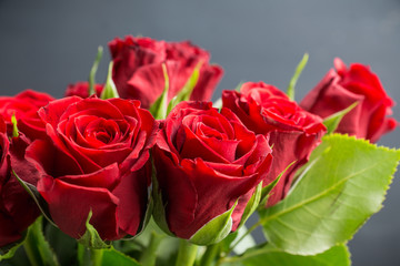 Bouquet with red roses on the rustic background. Shallow depth of field.