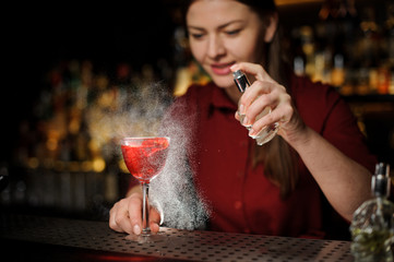 bartender girl adds peat whiskey to alcoholic cocktail