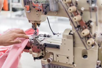 a seamstress sews clothes at the sewing machine. textile workshop. closeup