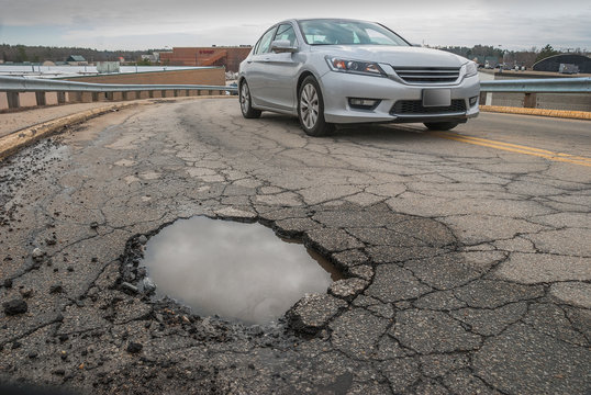 Non Descript Car Steering Clear Of Big Pothole