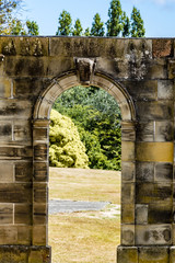 Architectural details of old buildings, green trees in background. Ruins of prison, Port Arthur, Tasmania, Australia, World Heritage Site.