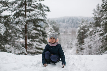 Fototapeta na wymiar Little girl in the winter snowy Park.