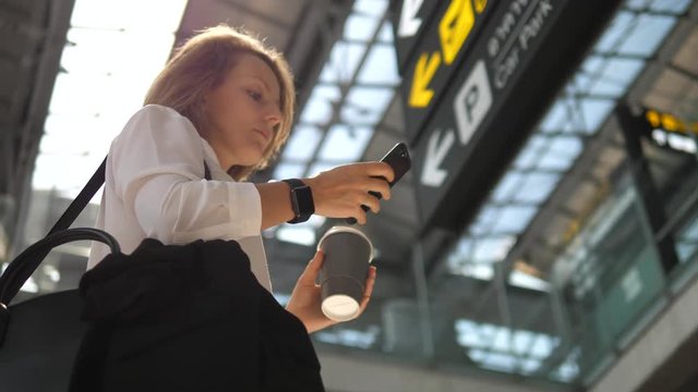 Passenger Traveler Business Woman Wearing Smartwatch In Airport Using Smartphone