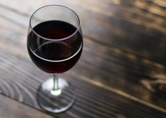 A glass of wine on a wooden background.