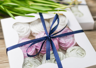 Marshmallow in a gift box on a wooden background. Sweet gift.