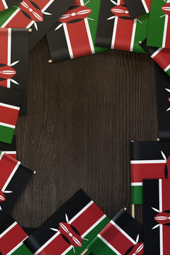 Kenya small flags framing a wood texture background with copy space