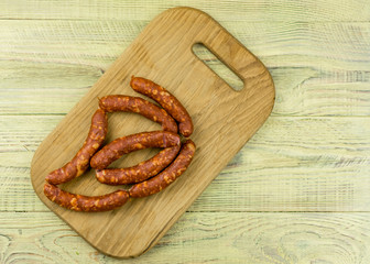 Smoked natural sausages   on a wooden surface.