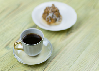 Coffee in a retro cup and cake on a wooden background.