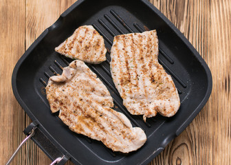 Grilled meat on a wooden frying pan.