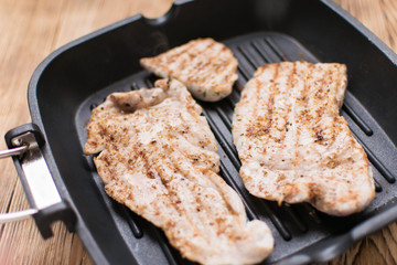 Grilled meat on a wooden frying pan.