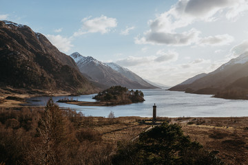 View of the Glenfinnan Monument, Loch Shiel and Scottish landscape near Glenfinnan, Inverness-shire, Scotland, on a cold spring sunny day.