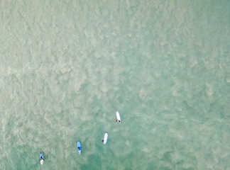 Surfers on the boards in the ocean. Aerial top view