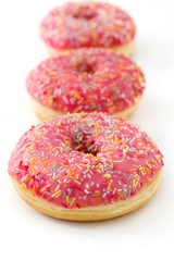 Pink frosted donut with colorful sprinkles isolated on white background